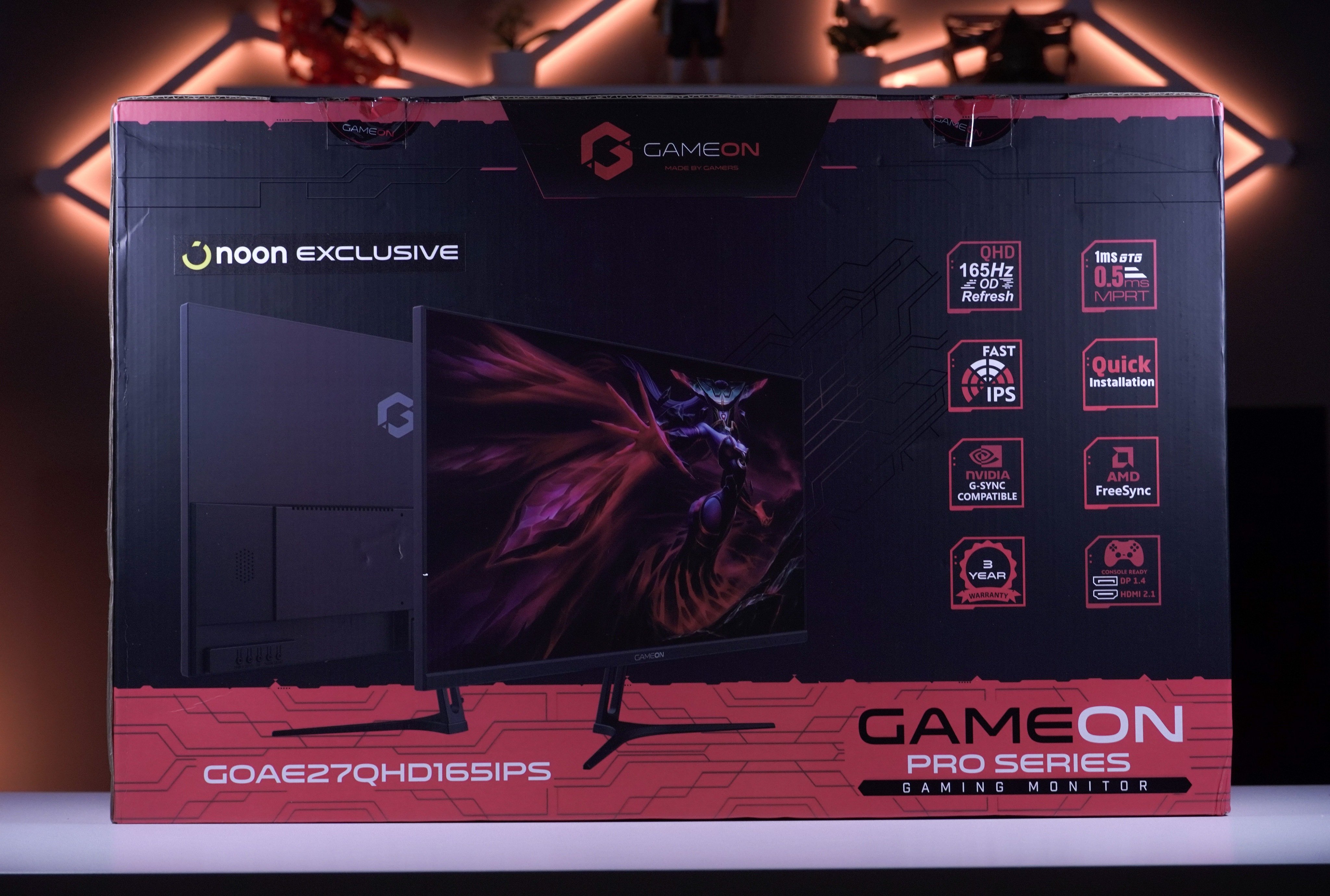 واجهة صندوق شاشة GameOn GOAE27QHD165IPS على المكتب بإضاءة خلفية دافئة.