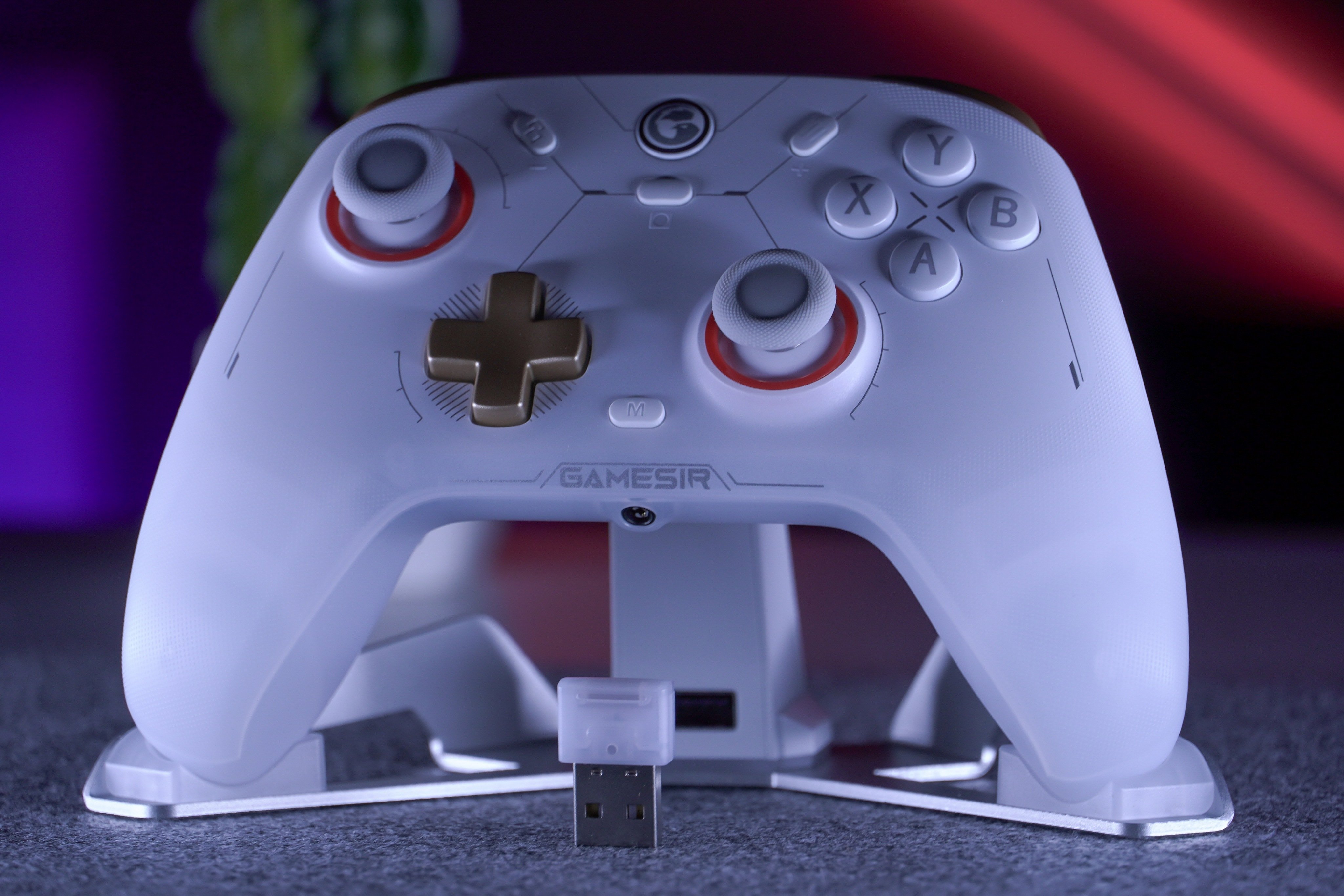 يد GameSir Cyclone 2 البيضاء على قاعدة الشحن، مع مستقبل USB في المقدمة.